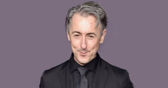 Alan Cumming Net Worth Alan Cumming in a black suit and tie, representing Alan Cumming Net Worth for a financial profile article.