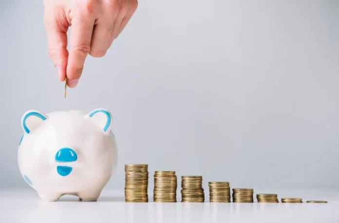 Child placing coins into a piggy bank, emphasizing tips to raise money-savvy kids and teach financial responsibility.