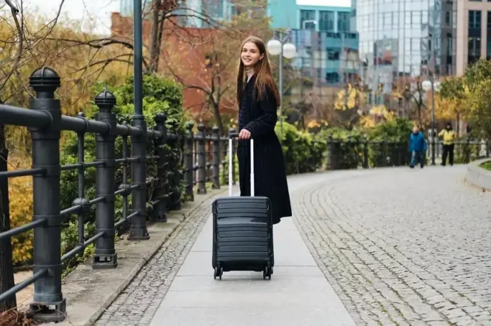 Traveler walking near St Pancras Station with suitcase after using luggage storage service in London