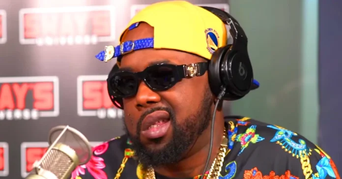 Conway The Machine wearing a yellow Warriors cap and headphones during a radio interview, estimated net worth of $10 million in 2025