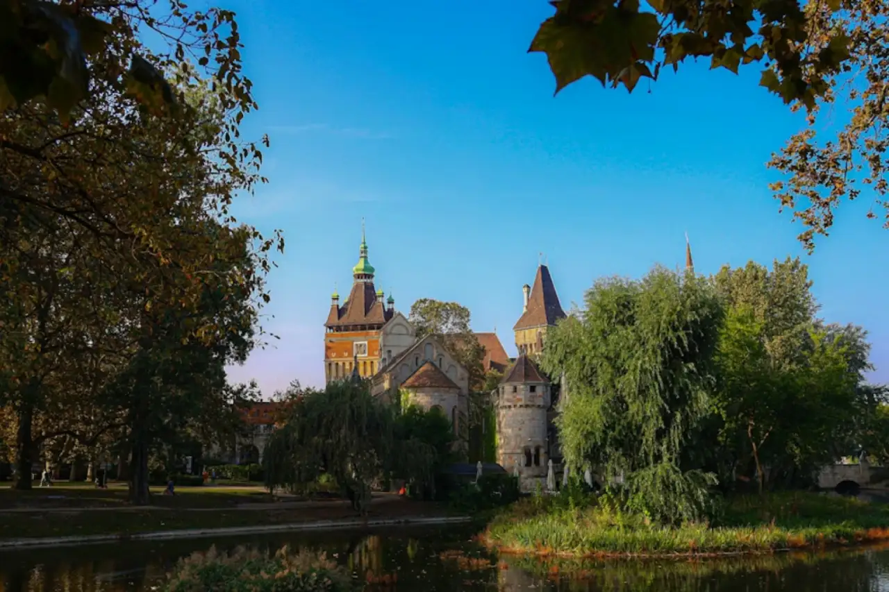 a large castle with towers and a lake in front of it