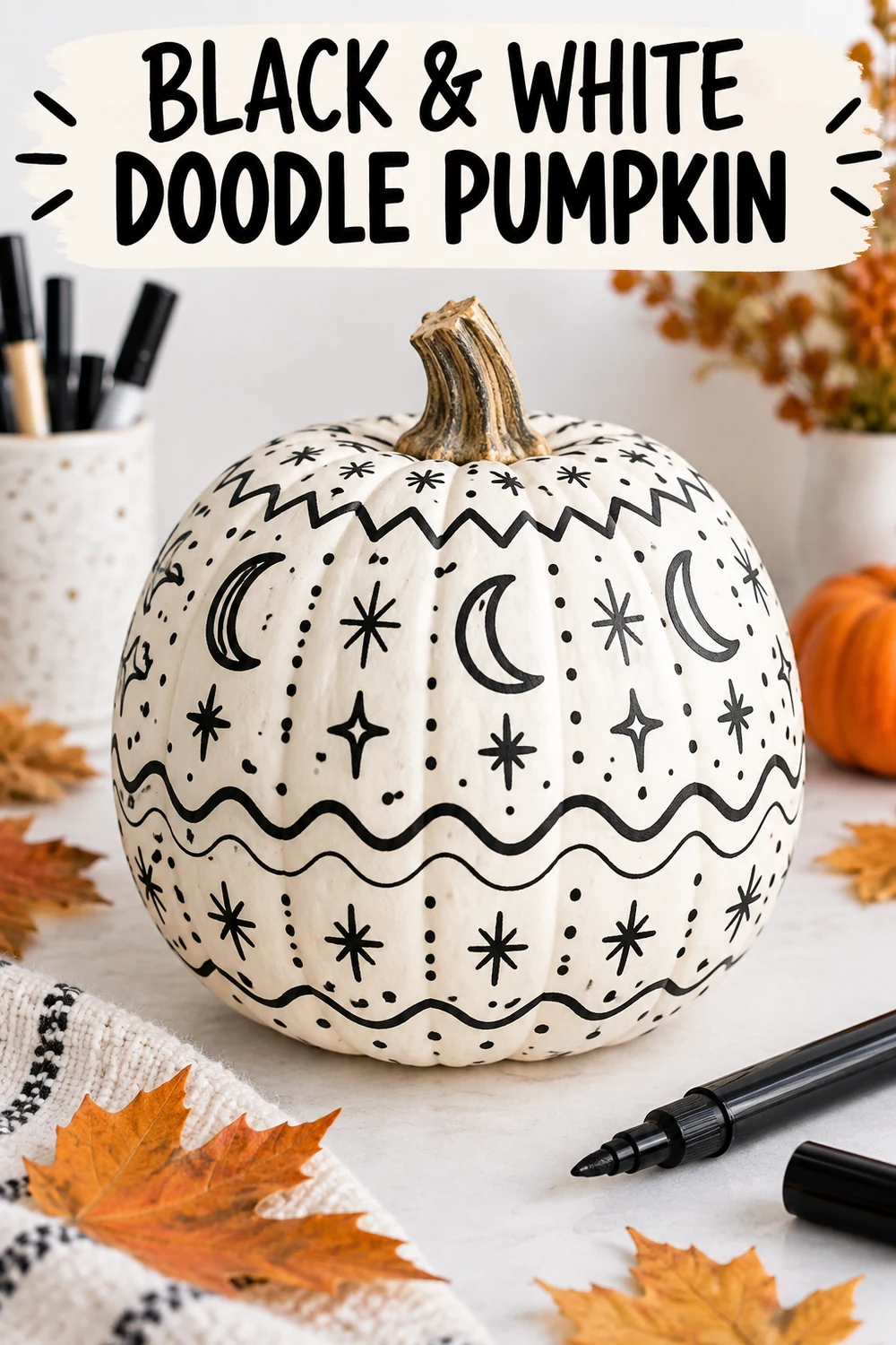 15 Halloween Pumpkin Decorating Ideas Without Carving 4 White pumpkin covered with black moons, stars, dots and hand-drawn doodle patterns
