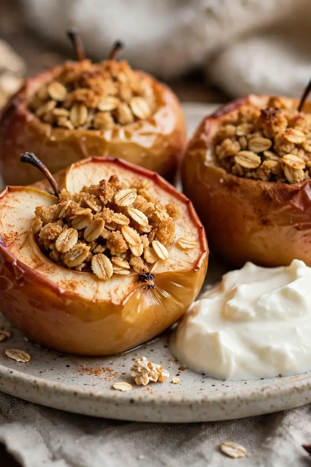 15 Winter Comfort Food Ideas That Are Lighter Than Usual 5 Baked apples filled with oats on a plate with a dollop of yoghurt.